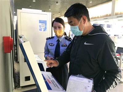 5月10日，交警指导群众通过自助选号机选号。